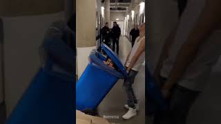 Niall Horan pushing Harry Styles in a garbage bin