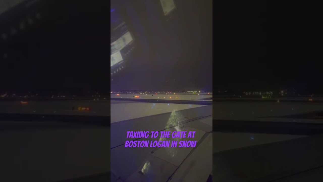 Taxiing to gate at Boston Logan airport in the snow at night 