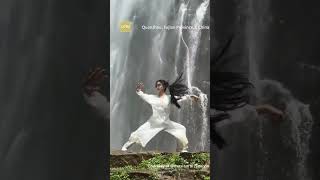 In front of a roaring waterfall in Fujian Province, a young woman was seen practicing Tai Chi.