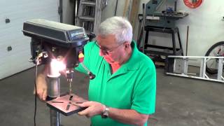 Drill press jig that helps you hold a round doweling while drilling a hole down the center.