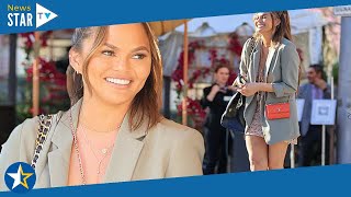 Chrissy Teigen cuts a chic figure in floral dress with olive hued blazer and boots for lunch in LA5