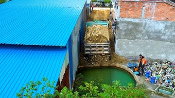 Bulldozer work hard in the narrow area push the stone and tree dump truck unload the stone