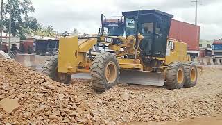 Tipper Truck is offloading Gravel material for Caterpillar Grader 140H to spread and level.