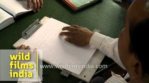 Visually challenged man writing in braille script at Central braille press