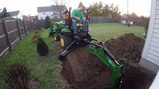 Compact Tractor Backhoe digs hole for basement egress window