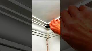 Putty knife smooths crack, corner sealed