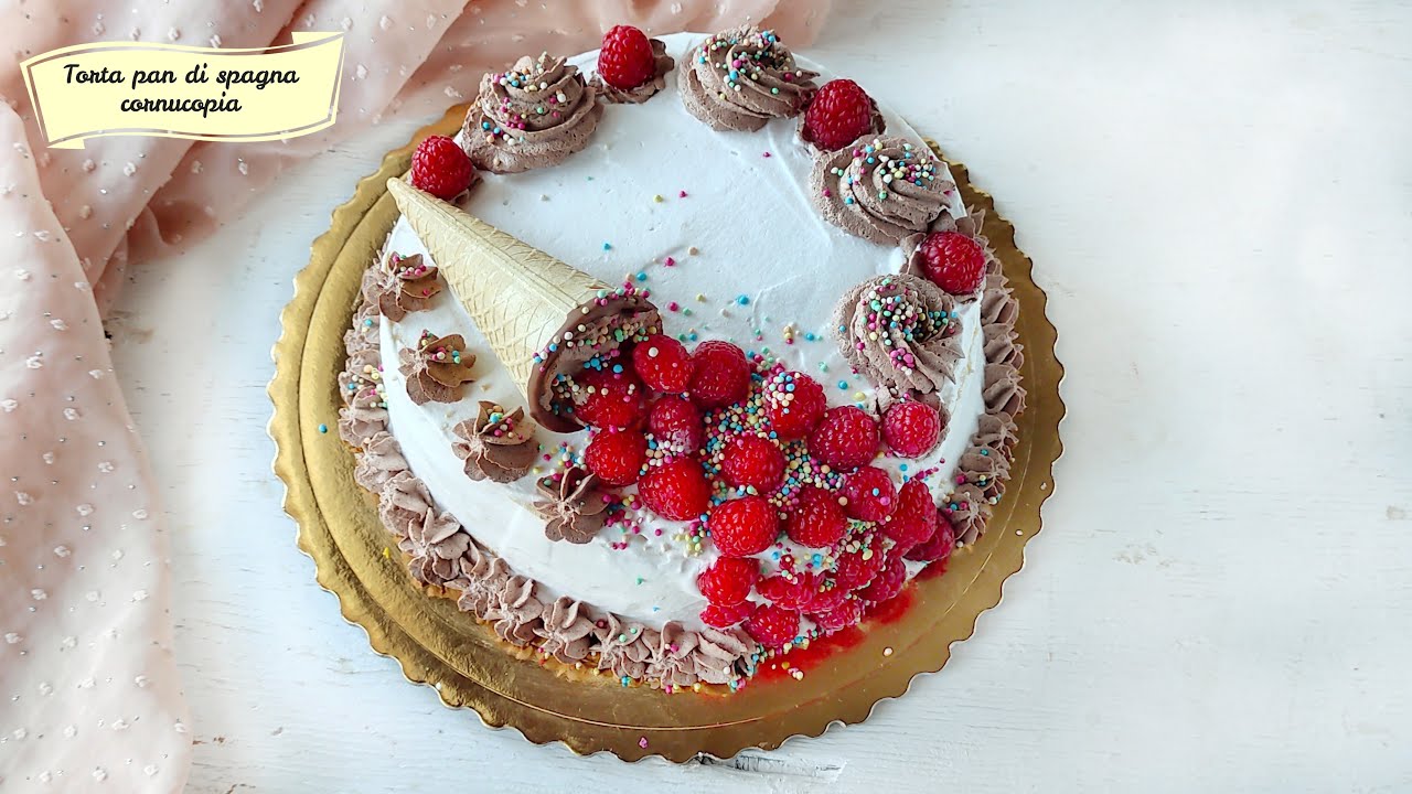 Torta di pan di spagna con cornucopia, farcita di crema pasticcera ricoperta di panna