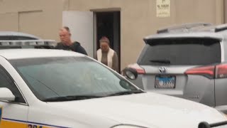 Two people are seen being brought out of Tang Dynasty Foot Spa in handcuffs and placed into patrol v