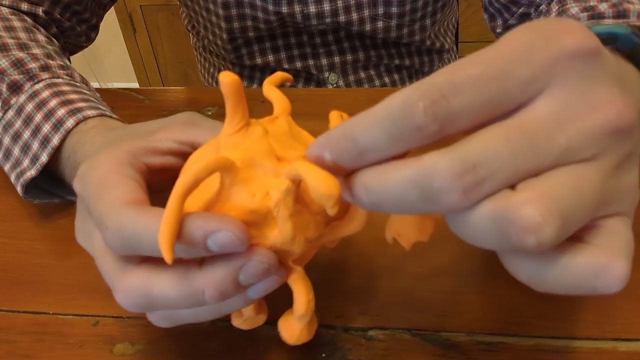 Making a statue sculpture out of orange colored clay 14