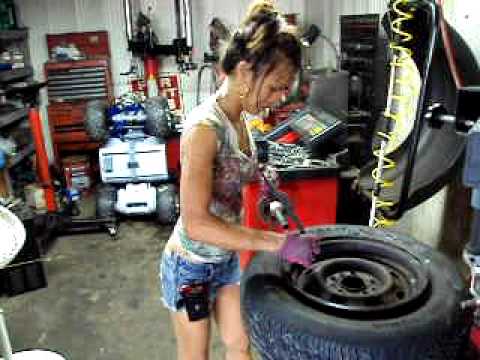 ASIAN LADY CHANGING TIRES AT TIRE SHOP IN FLORIDA