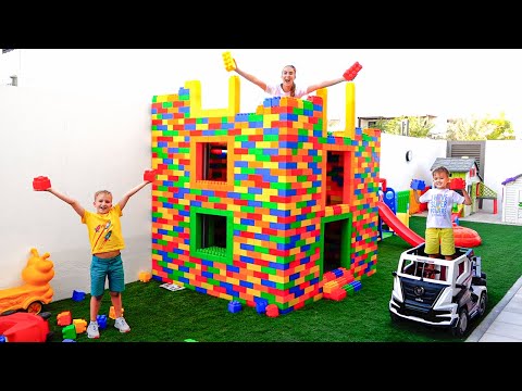 Vlad et Niki jouent avec des blocs de jouets colorés et construisent une maison à trois niveaux
