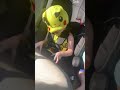 adorable 3 year old jamming to metal music in his car seat wearing an anime cap ove his eyes