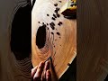 carving a large round wood piece using a sharp manual chisel tool on a workbench carefully