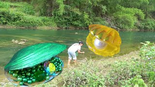 Prying open the big clam in the fresh water, the girl obtained a unique treasure trove of pearls