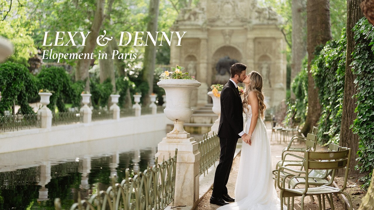 Bride and groom kiss beside a fountain in a Paris garden, with warm light and green chairs nearby