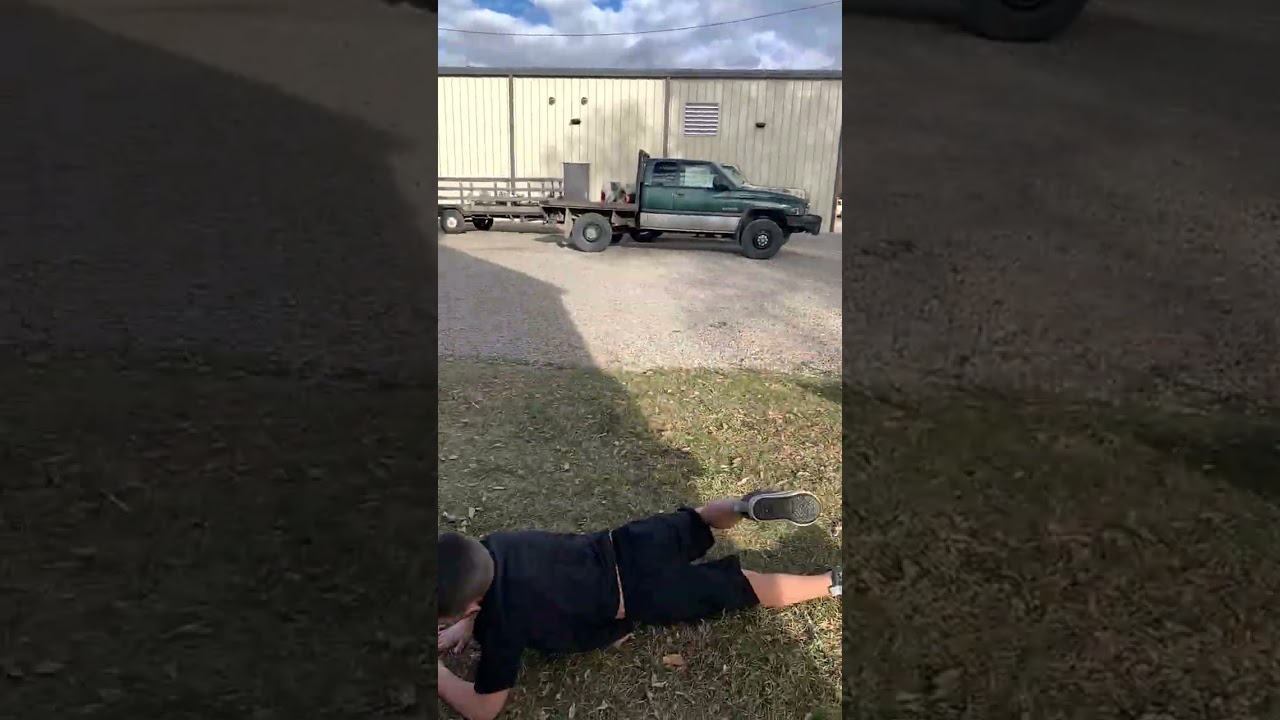 Boy jumps from top of red Little Tikes Cozy Coupe car and bellyflops on his stomach lands on grass