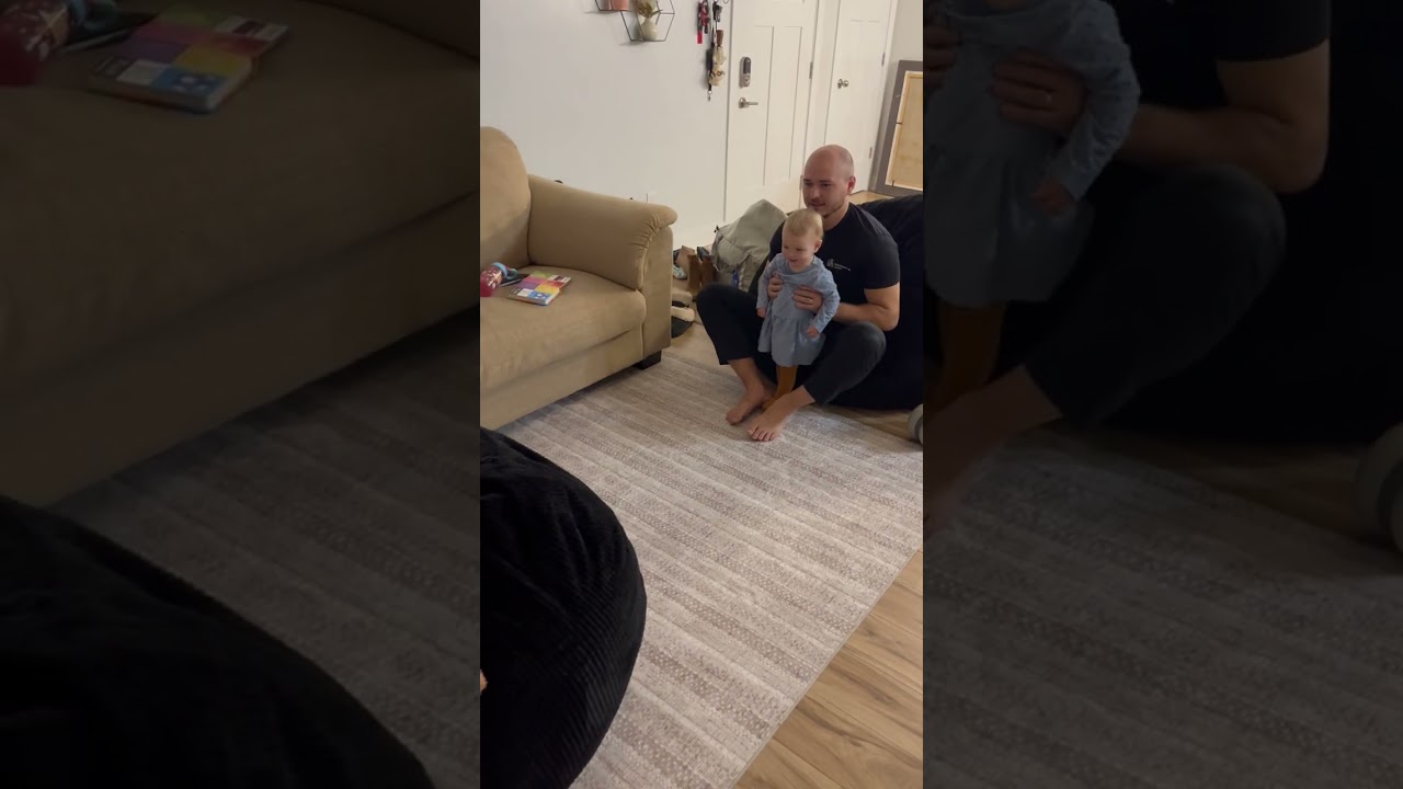 Dad throws girl on bean bag chair then bounces off and bumps back of head on floor on living room