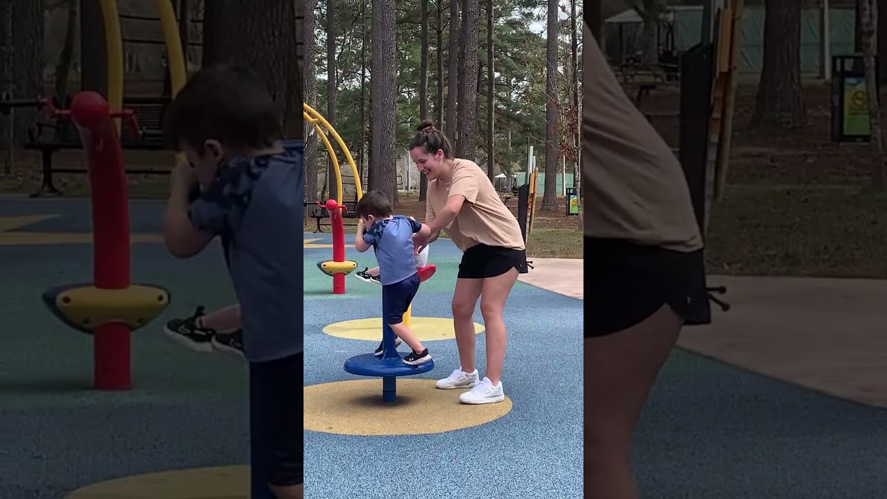 Little boy goes on red spinning ride at playground and gets real dizzy then falls on the ground