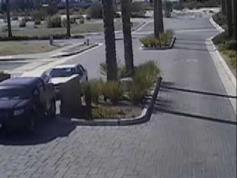 Silver/blue sedan follows a car and hits the security arm