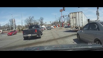 Blocks busy intersection, gets out and threatens other driver with pipe