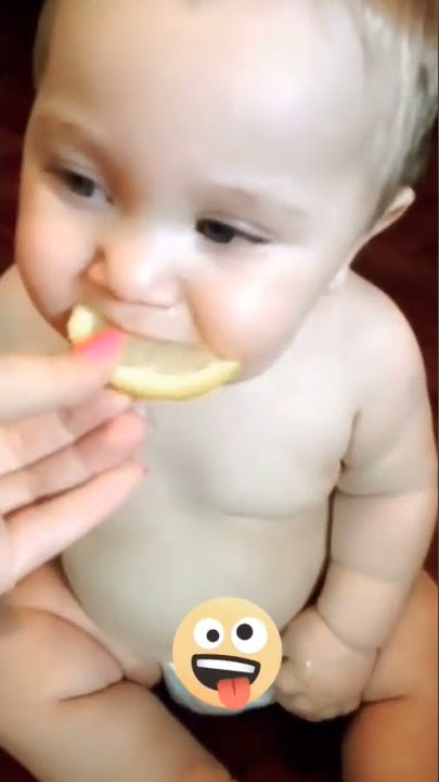 bayi lucu makan lemon tersenyum