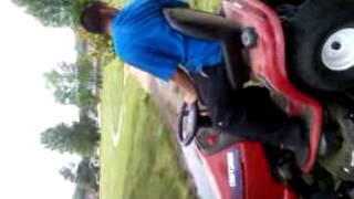 Mexicans using a lawn mower to unden a car