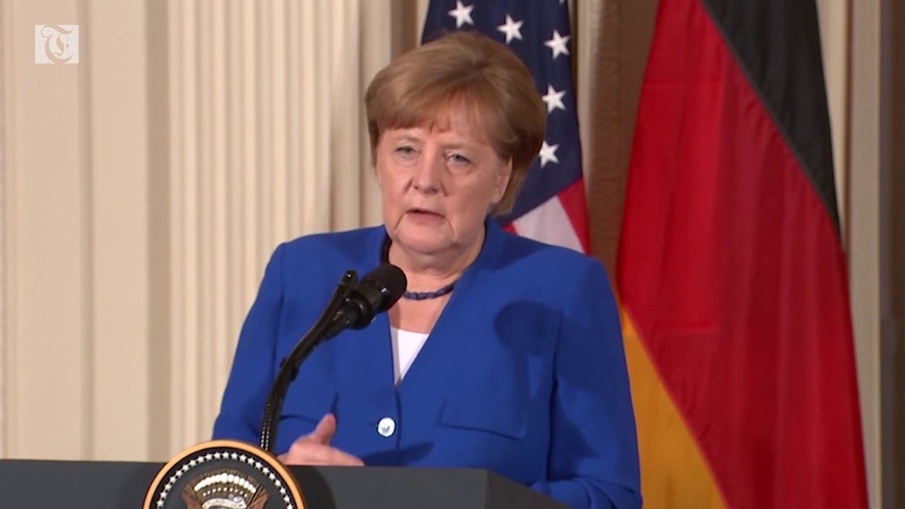 Trump Blasts Merkel From A Distance; Smiles During Face-To-Face Photo Opp