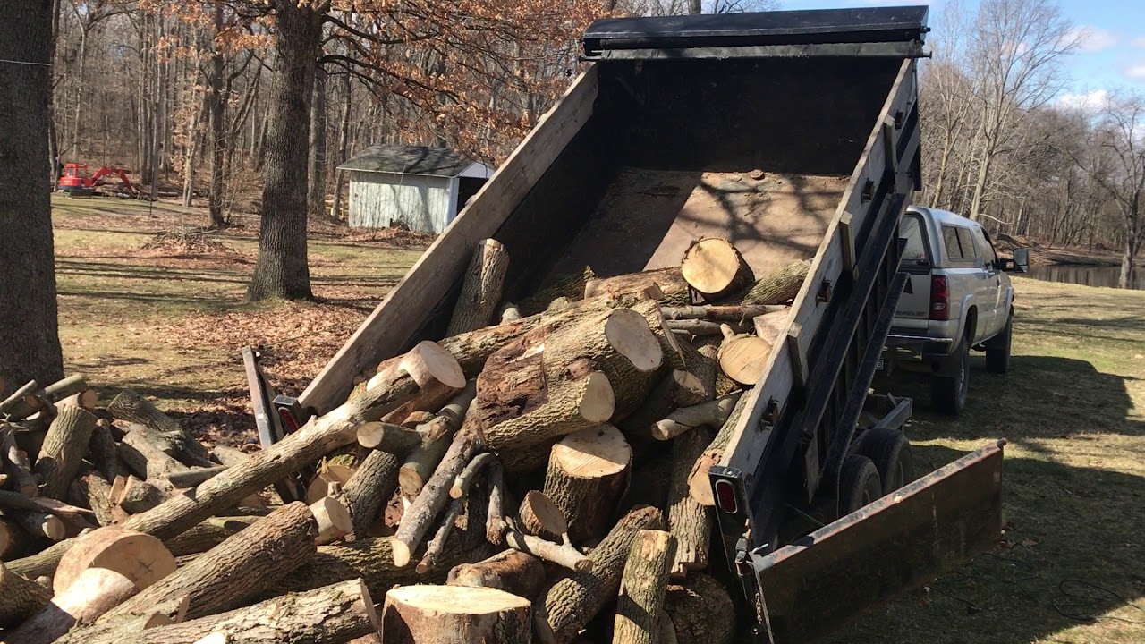 Unloading a dump trailer full of firewood - YouTube
