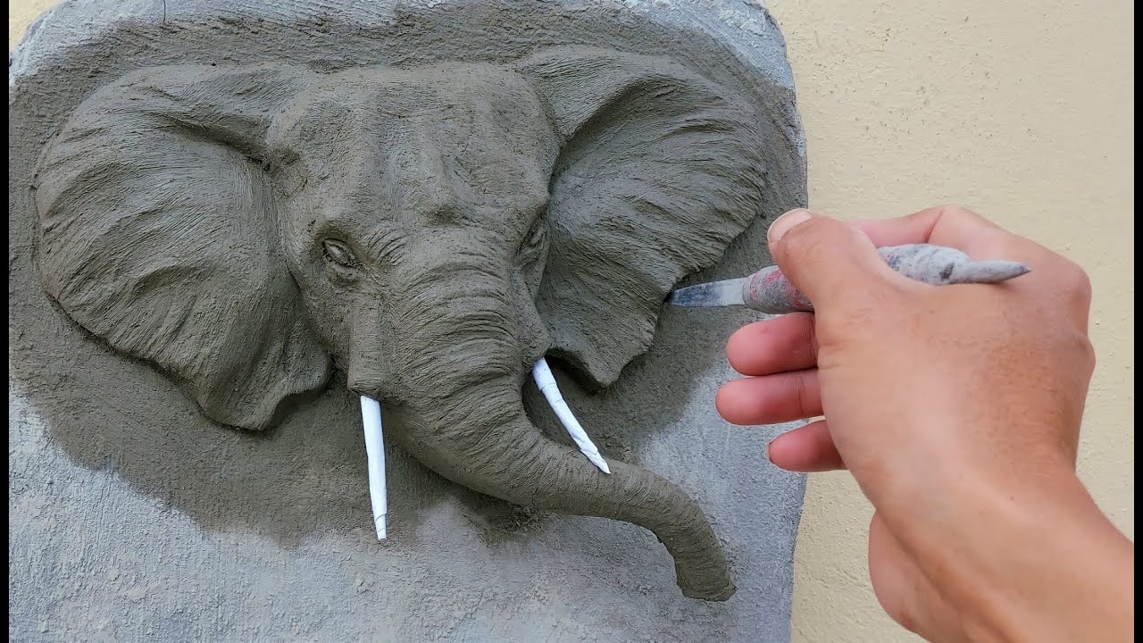 Marvel at the cement relief / elephant head, protruding trunk