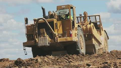 Cat 637 Twin Engine Scrapers Unloading in the Pile - Heavy Equipment Land Balancing