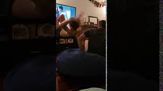 Boy lays on bean bag then dad's jumps on it and boy goes flying near TV