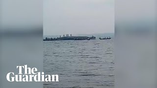 People on the capsized hull of sunken ferry in Tanzania's Victoria Lake