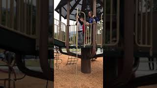 Boy goes down pole upside down at playground and bumps his head on the ground