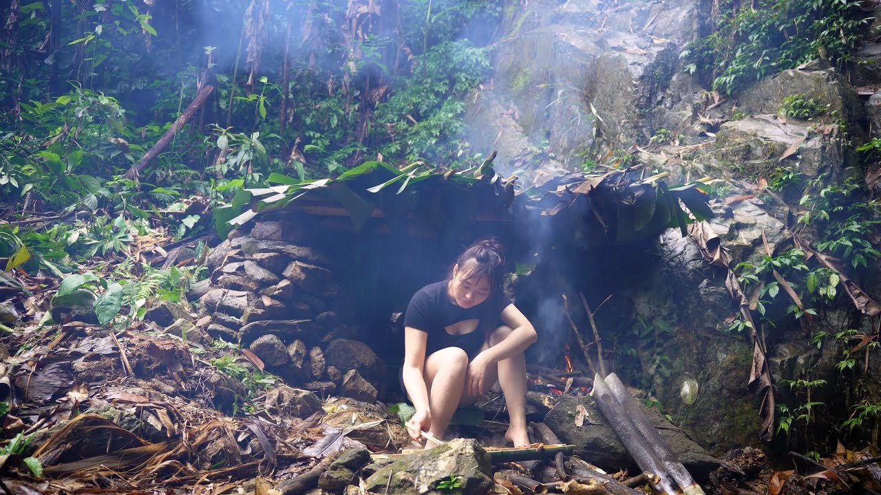 Solo camping in heavy rain. Build a primitive shelter using rocks and ...