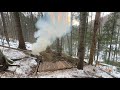 Building underground bushcraft shelter for survival in the winter forest a dugout under the roots