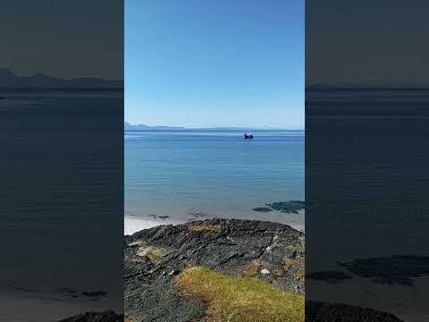 At the Twin Beaches on Gigha, a Calmac ferry passing the Paps of Jura in the distance