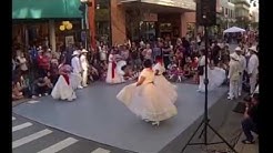 Folk dancers in traditional attire dancing.