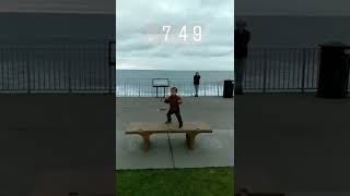Kids runs off of bench by the boardwalk