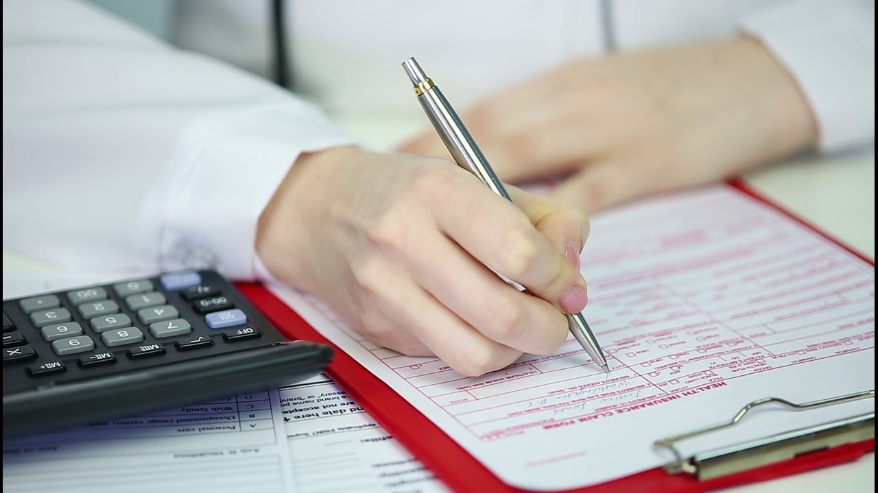 Closeup of doctor�s hands filling in health insurance