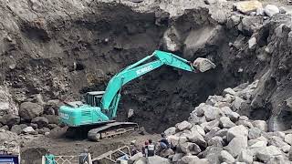 heavy equipment operators have little difficulty dropping large stones in sand mining
