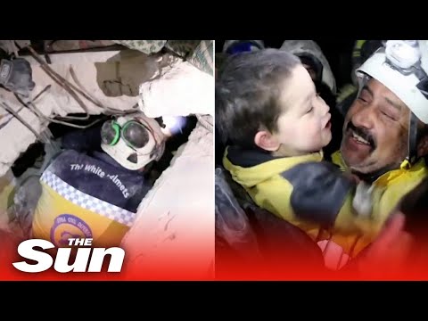 Syrian boy smiles after being pulled from the rubble of collapsed building in Armanaz