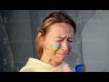 War portrait of Ukrainian woman with national flag on cheek crying