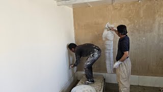 Working of white plaster inside Susan's house by the master worker