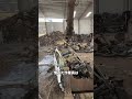 巨大アームで車を解体する廃車工場の作業現場