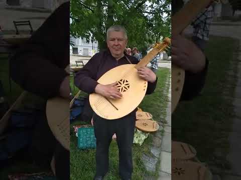 Юрій Кочержинський грає гопачок на власноруч виготовленій кобзі біля НМІУ 21 травня 2022 року