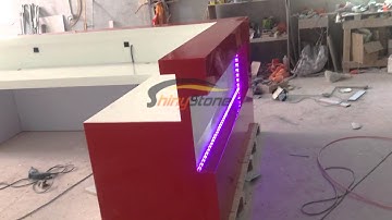 Red glossy solid surface reception desk with RGB led lighting