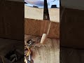 carving a precise vertical groove into a thick block of wood using a sharp metal chisel woodworking