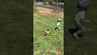Boy rides bike down grass hill and flips over