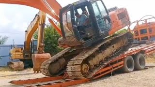 The process of raising and lowering a Hitachi excavator from a self-loader involves several steps: