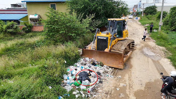 Amazing bulldozer start new project pushing soil, clearing trash and filling land with trucks